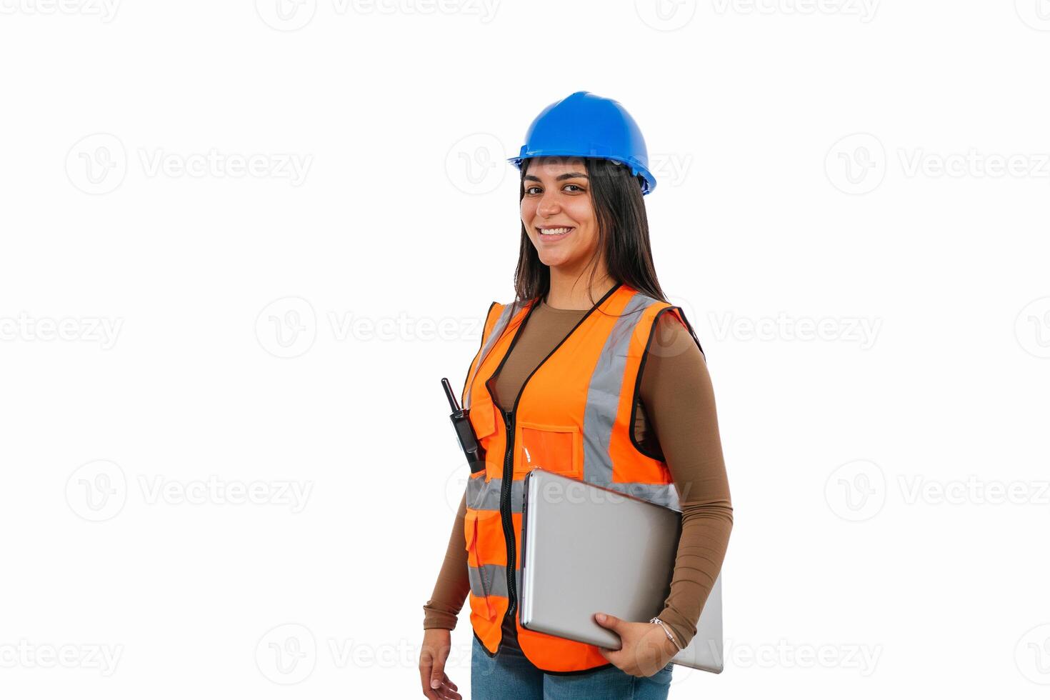 Smiling latin construction worker woman holding laptop and walkie-talkie photo