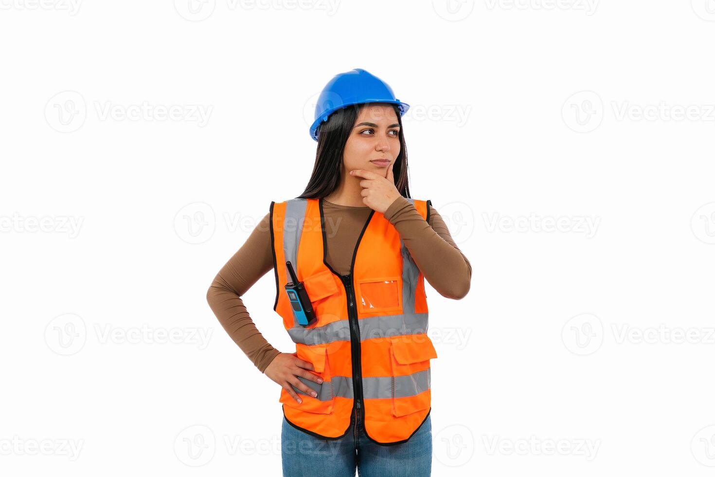 Pensive female engineer wearing safety vest and hardhat is holding her chin photo