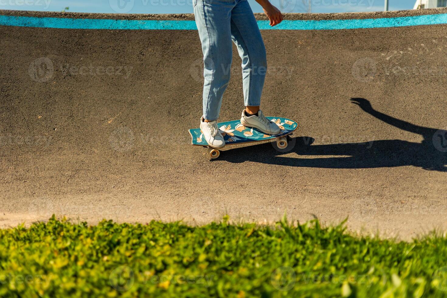 Young woman surf skating in a pump track during a sunny day photo