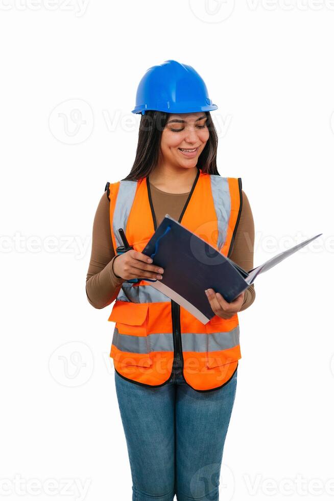 vertical Latina construction worker reading a project while holding a walkie-talkie photo