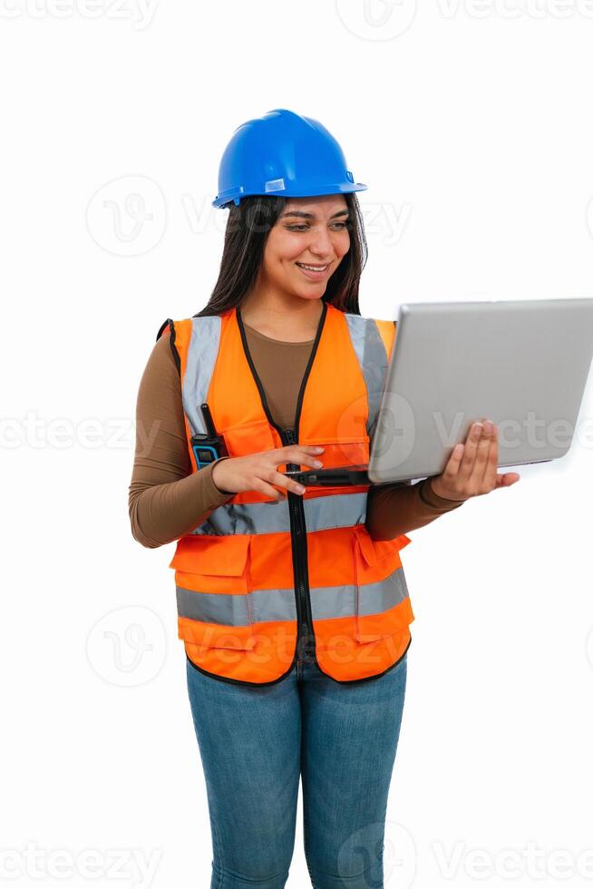 vertical Smiling female architect wearing safety vest and helmet using laptop photo