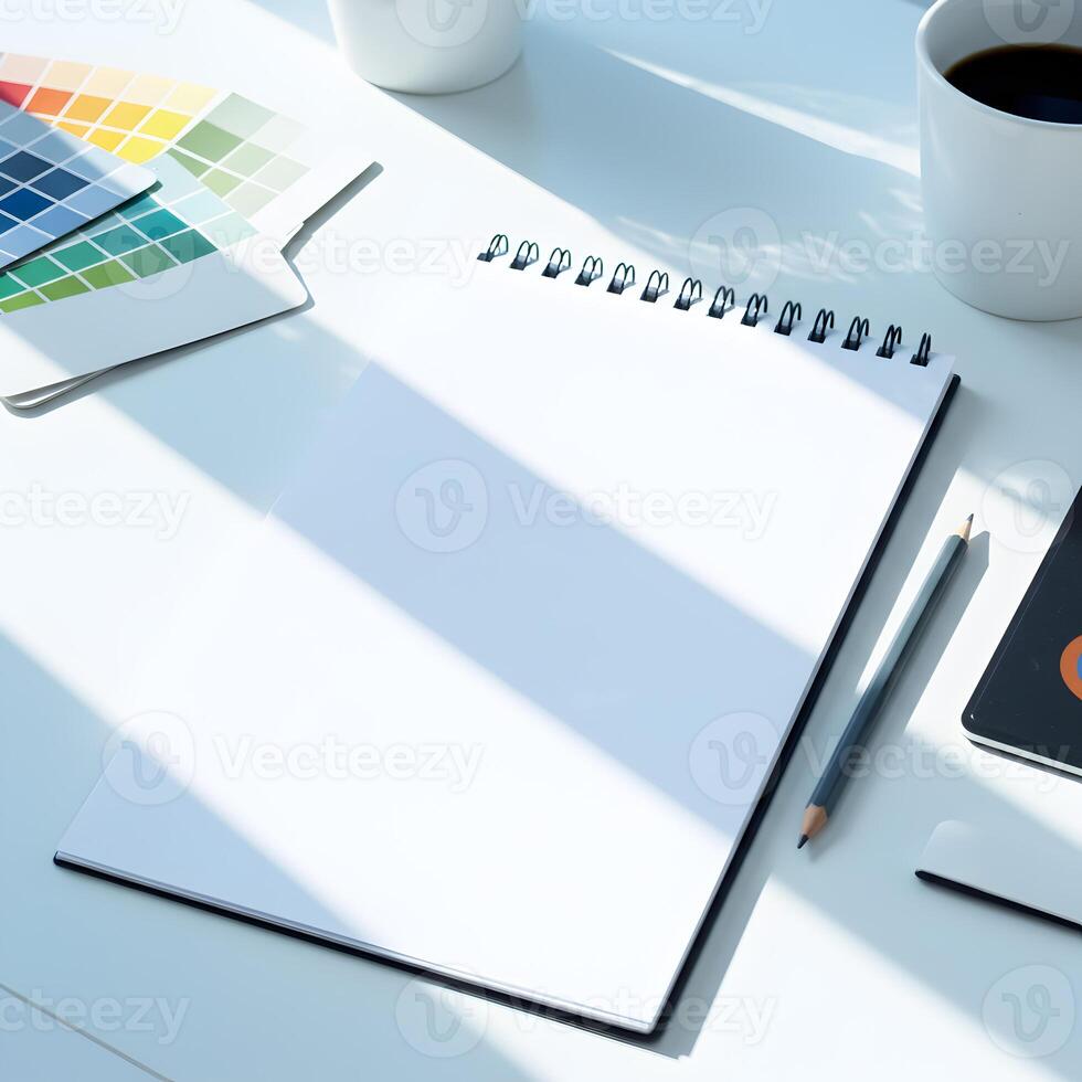 A white desk with a notebook, coffee cup and other items photo