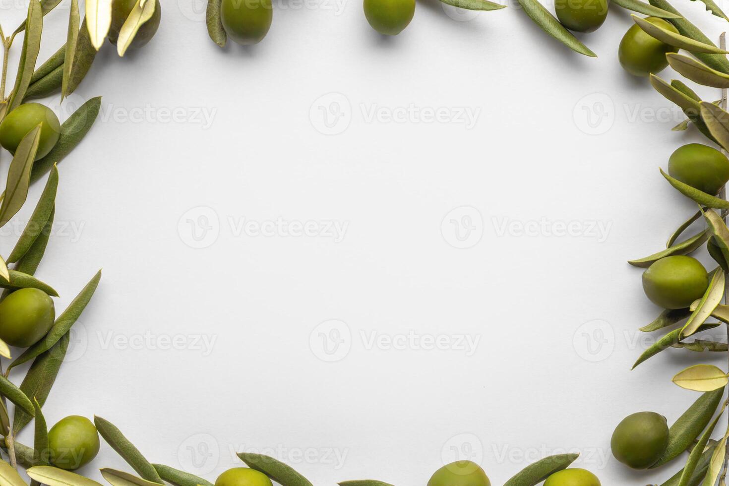 Minimalistic frame made of fresh green olives and branches on a white background photo
