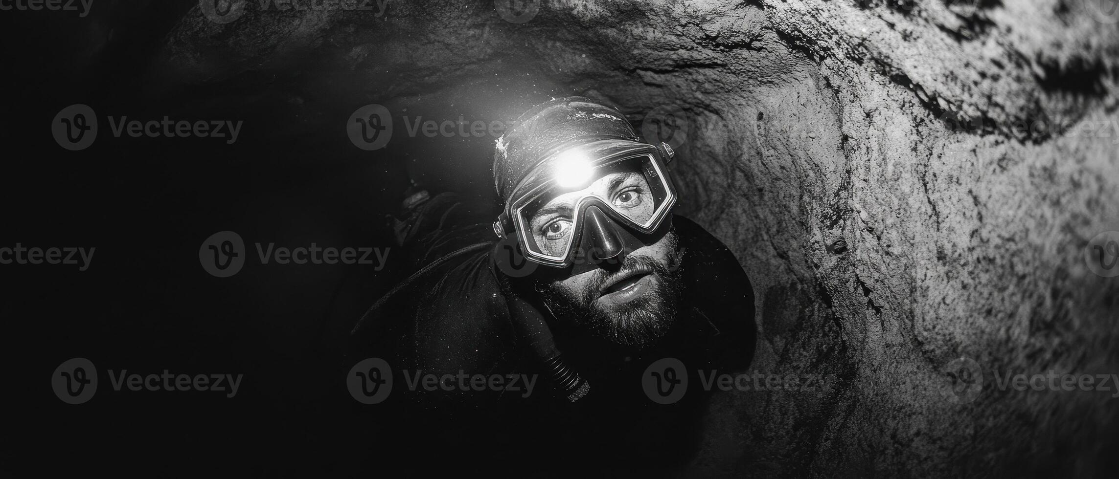 A diver explores an underwater tunnel, illuminated by a headlamp, capturing the essence of adventure and discovery in a dark environment. photo