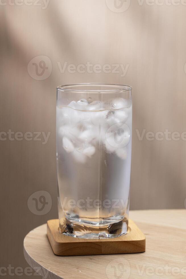 Cold water fills a glass, ice cubes floating within. photo