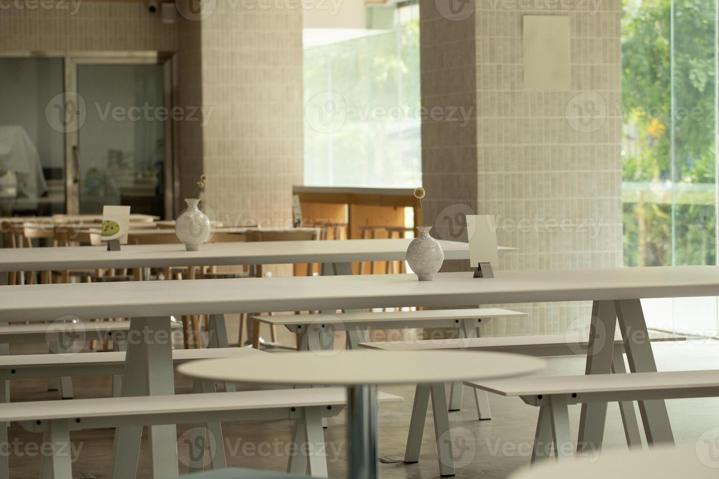 Serene cafe interior features minimalist tables and soft lighting. photo