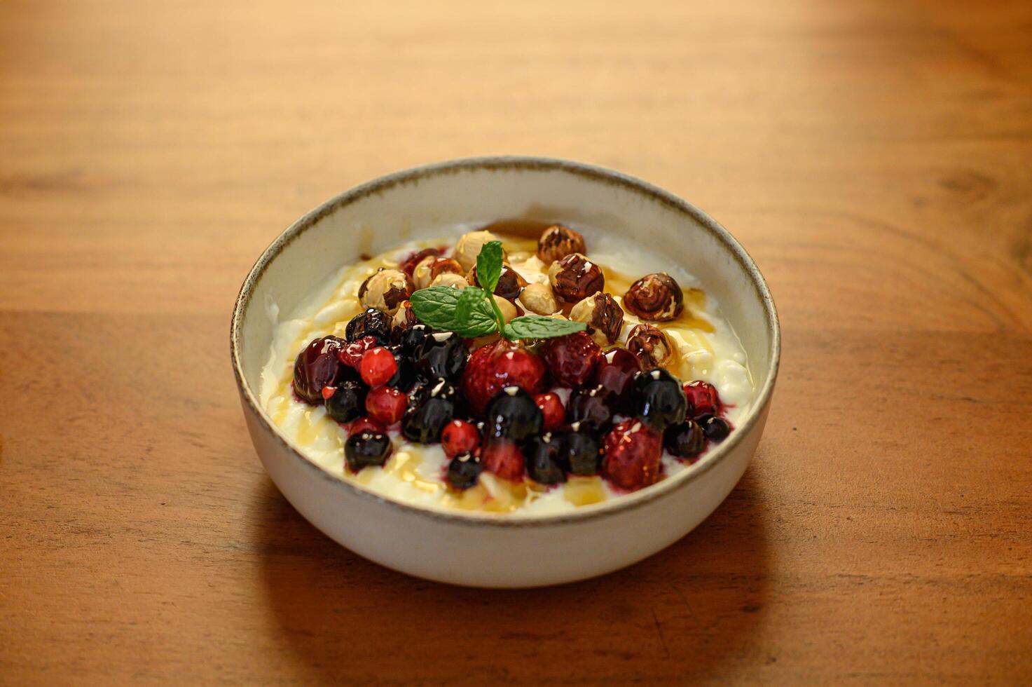 A beautifully arranged bowl of yogurt, topped with fresh fruits, nuts, and honey for healthy breakfast. photo