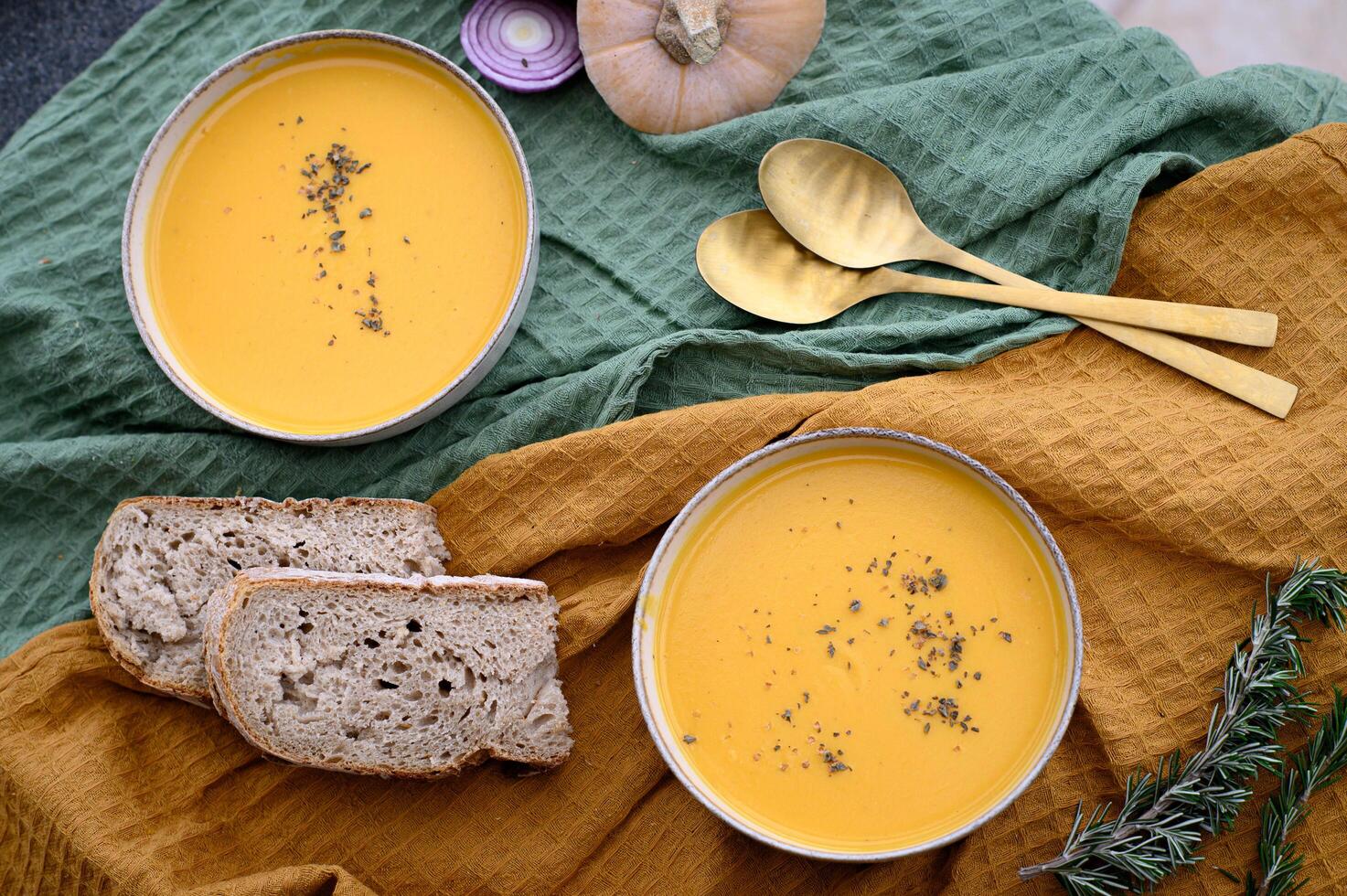 A rustic food composition with hearty pumpkin soup and artisan whole-grain sourdough. photo