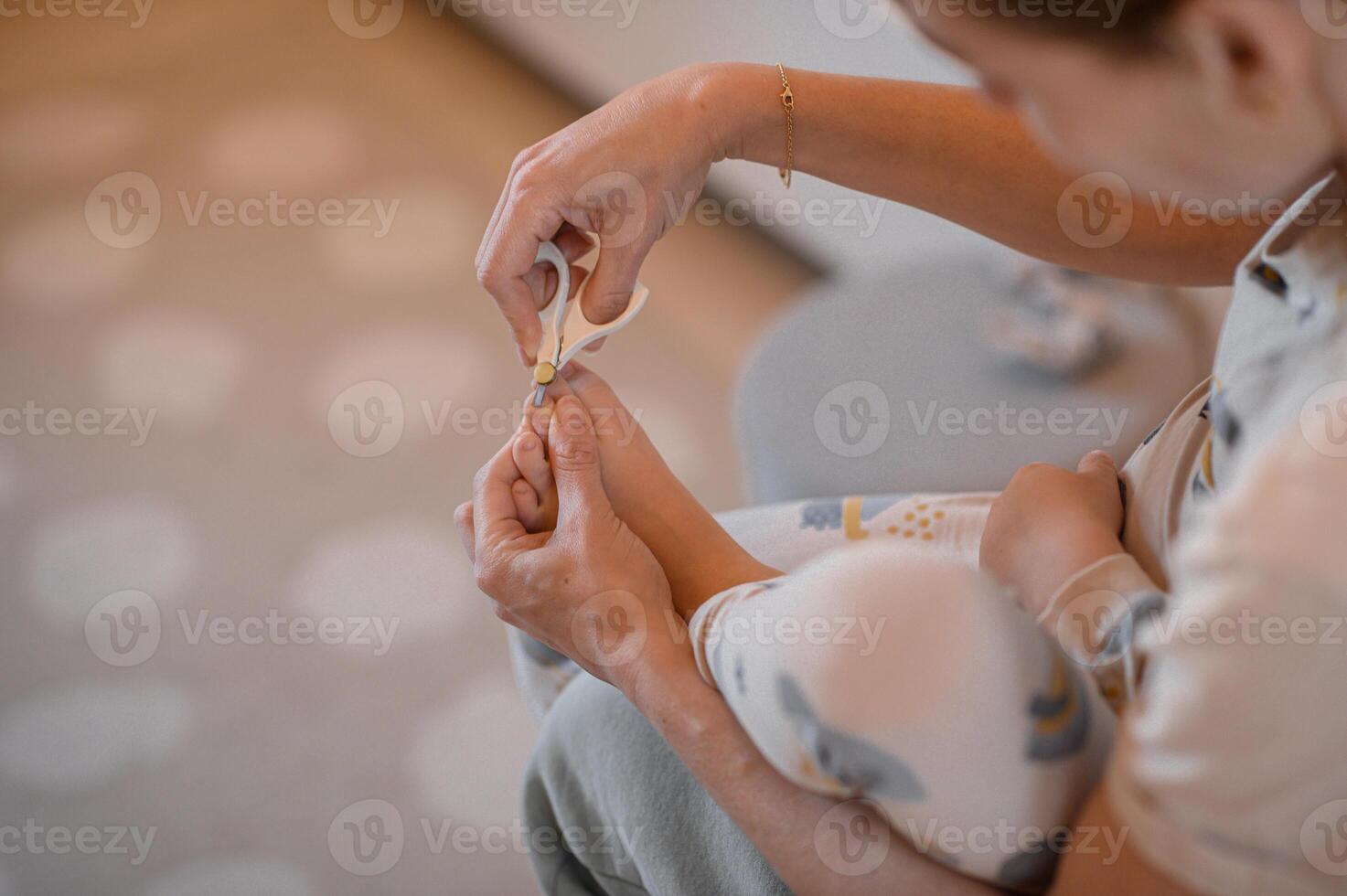 A mother trims her babys toenails with delicate safety scissors, ensuring precision and care. photo