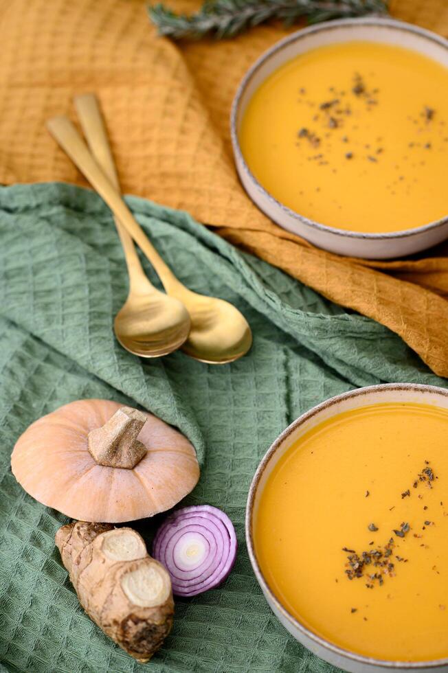 A cozy autumn scene featuring a creamy pumpkin soup with sourdough whole-grain bread. photo