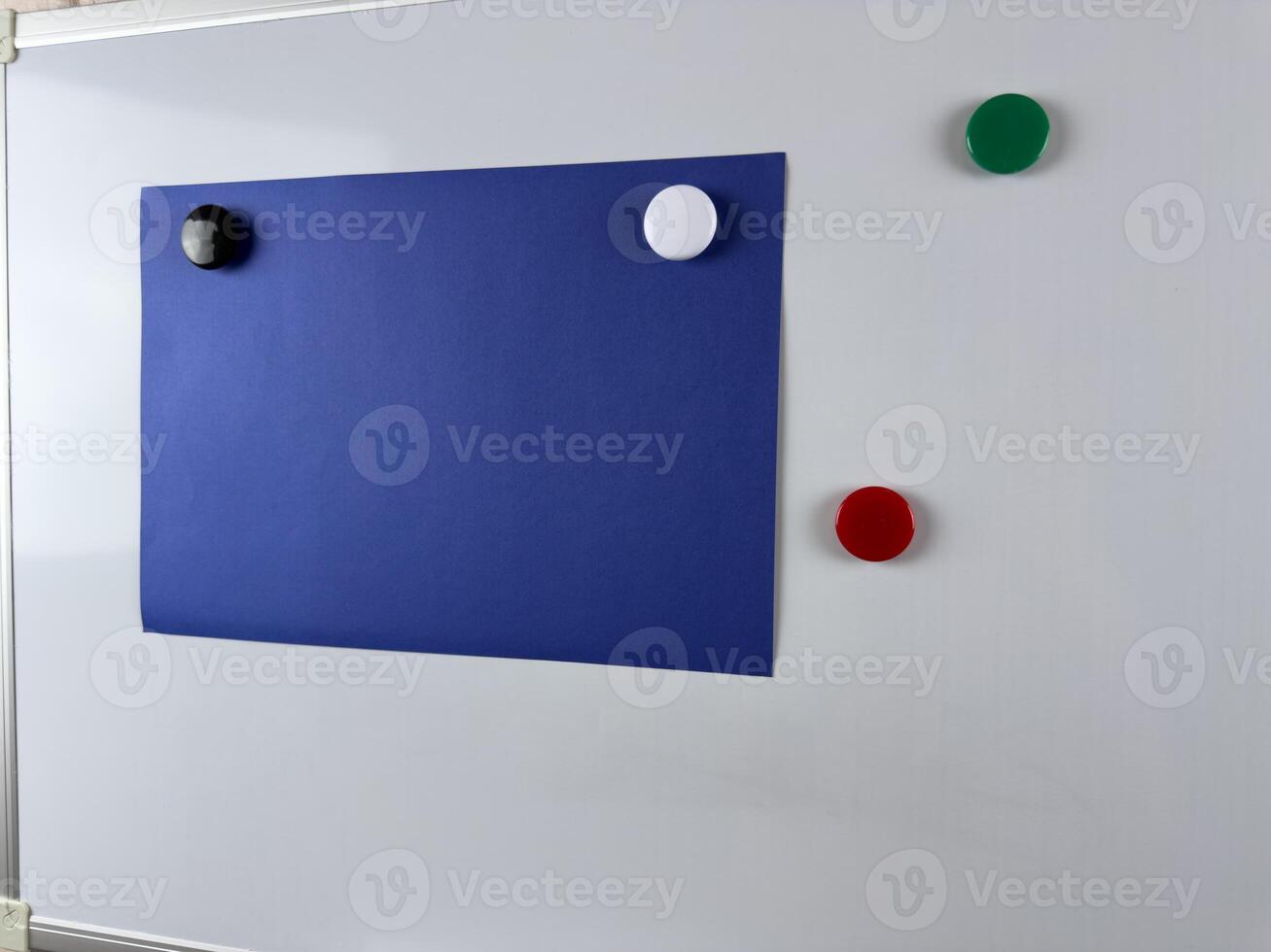 Large blue paper note pinned to whiteboard with magnets. Ideal for workspaces that require organization and planning for increased efficiency photo
