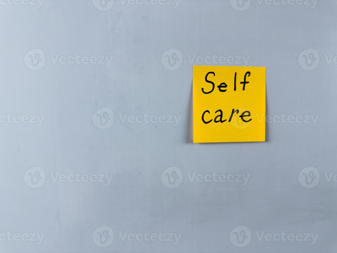 Sticky note with the words Self Care written on it, placed on white background. Ideal for illustrating themes of well being, health, and self love. Great for concept creation photo