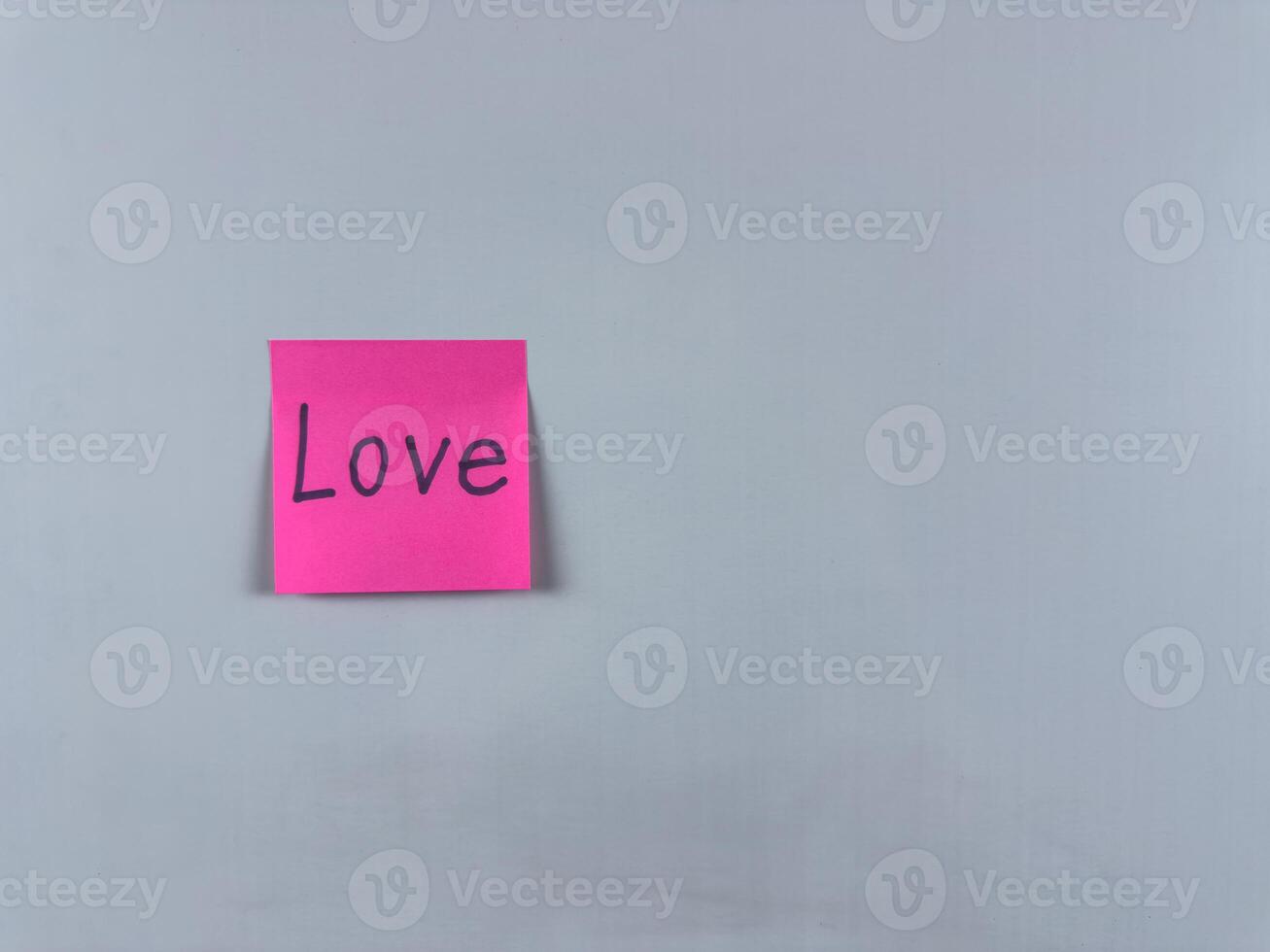 Sticky note with the word Love written on it, placed on a white background. Perfect for illustrating love, relationships, and emotional connection. Great for concept creation photo