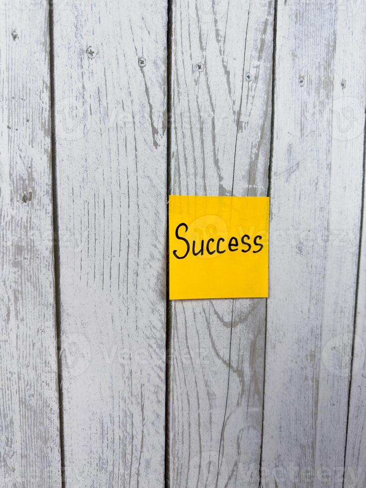 Sticky note displaying the word Success positioned on wooden background, symbolizing achievement, personal development, and the pursuit of life goals photo