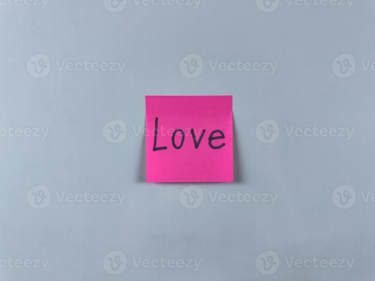 Sticky note with the word Love written on it, pinned on white background. Image represents affection, connection, and care. Ideal for illustrating concepts of love and relationships photo