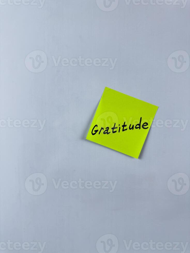 Sticky note with the word Gratitude written on it, placed on white background. Ideal for illustrating themes of thankfulness, appreciation, and positivity. Great for concept creation photo