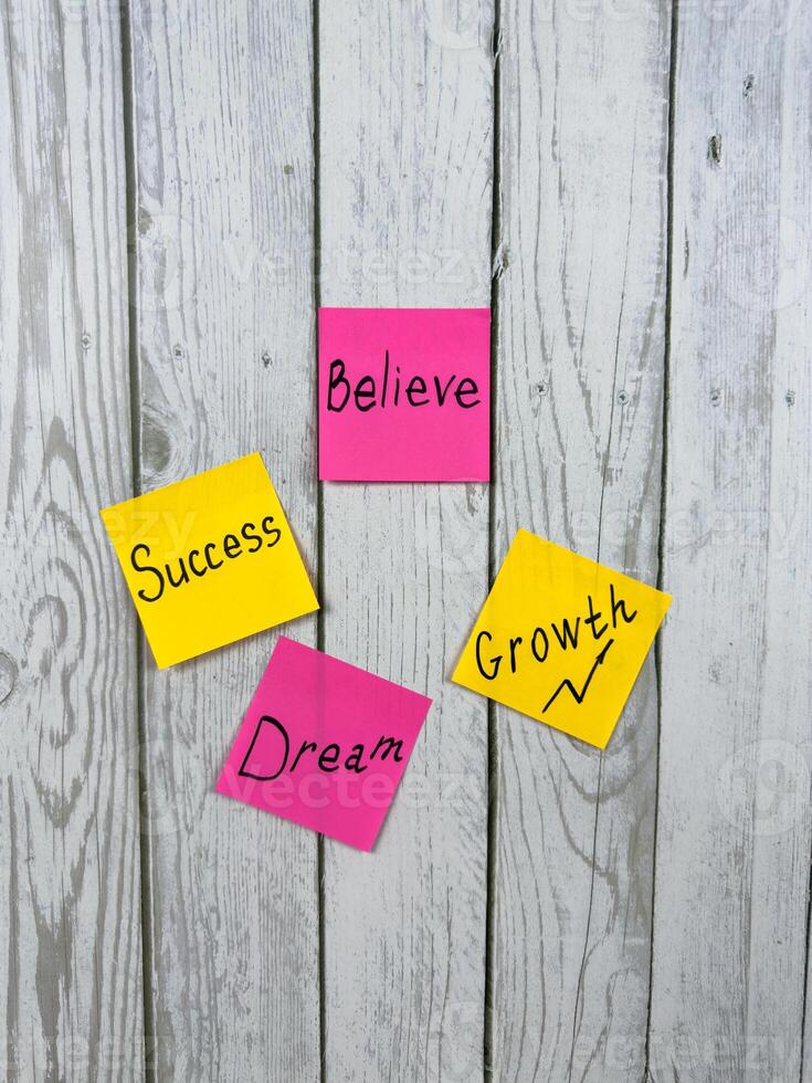 Collection of colorful sticky notes with motivational words on white wooden board. These words inspire personal development, goal achievement, and proactive planning photo