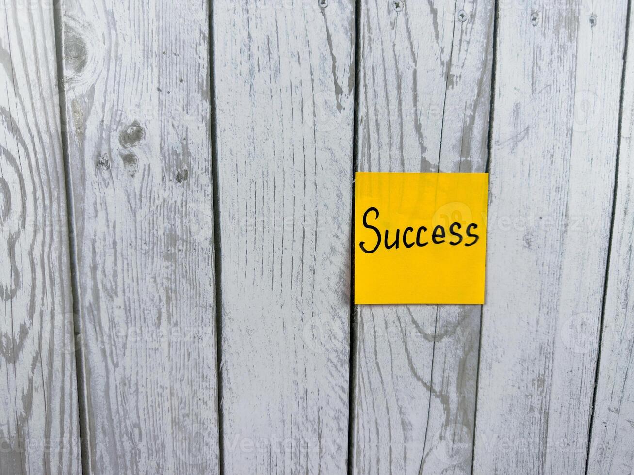 Sticky note featuring the word Success placed on a textured wooden background, symbolizing achievement, personal growth, and the pursuit of goals in life photo