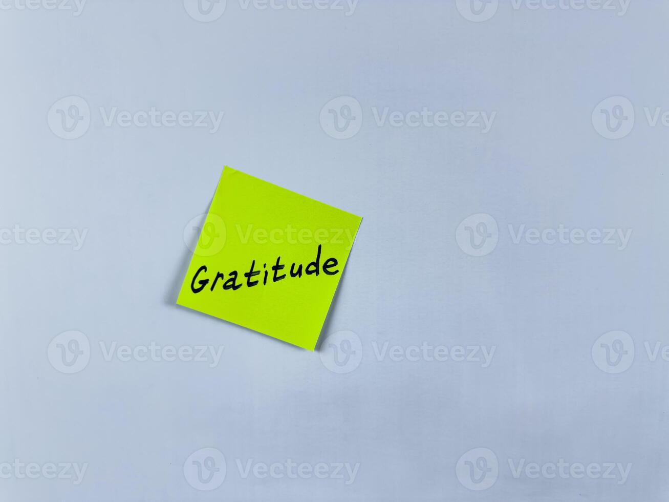 Sticky note with the word Gratitude, pinned on white background. Photo symbolizes thankfulness, appreciation, and positivity. Perfect for illustrating concepts of gratitude and gratefulness