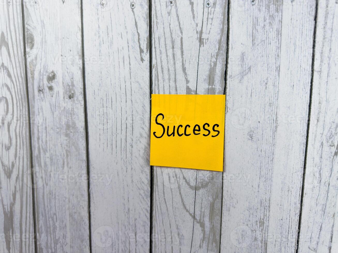 Sticky note featuring the word Success set against a textured wooden background, representing the essence of achievement, personal growth, and the pursuit of meaningful goals photo
