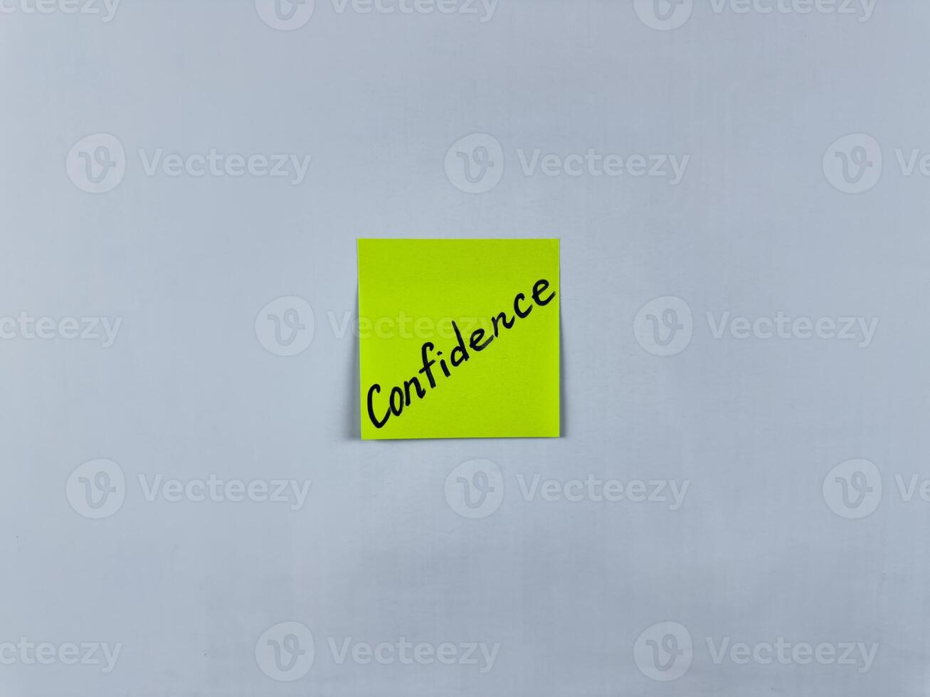 Sticky note with the word Confidence written on it, pinned on white background. Photo symbolizes self assurance, courage, and trust. Perfect for illustrating concepts of confidence in life