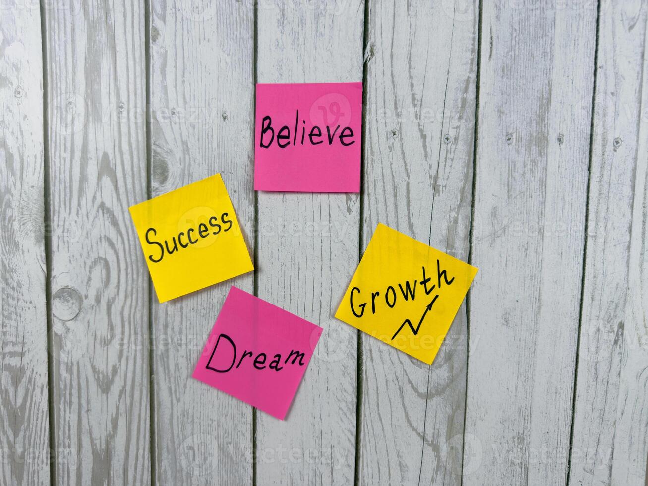 Collection of colorful sticky notes with words like Believe, Success, Dream, and Growth placed on white background. Photo represents themes of motivation, achievement, and personal development