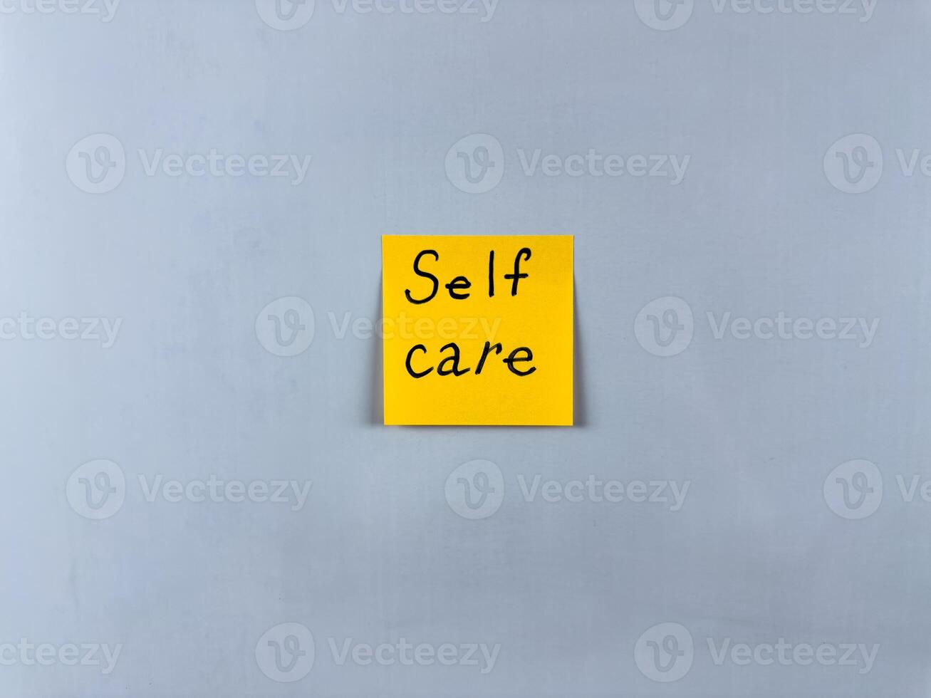 Sticky note with the words Self Care written on it, pinned on white background. Photo symbolizes well being, self love, and health. Perfect for illustrating concepts of self care and personal wellness