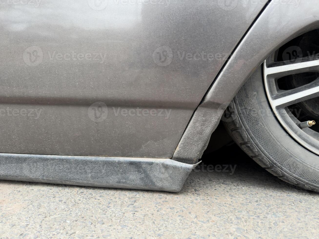 Customized old car with low suspension and dusty wheel. Popular style among young drivers is to lower their car as close to the ground as possible for sporty and stylish look photo