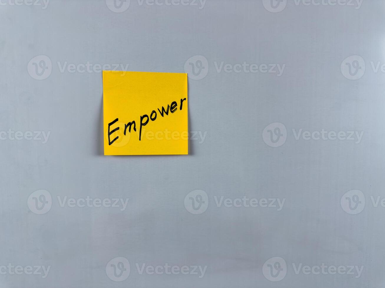 Sticky note with the word Empower written on it, placed on a white background. Ideal for illustrating themes of strength, confidence, and motivation. Great for concept creation photo