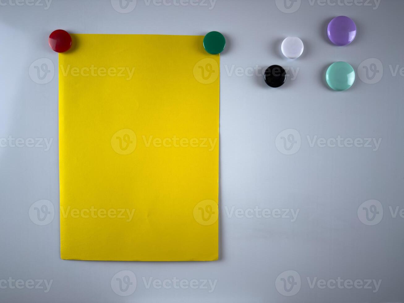 Bright yellow note attached to whiteboard with magnets. Perfect for organizing tasks and reminders in office or classroom setups. Enhancing productivity and communication photo