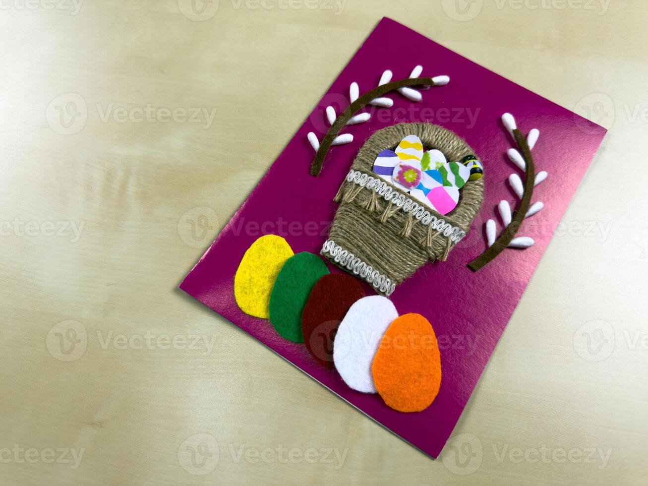 Vibrant handmade Easter card showcases a charming basket filled with felt eggs and flowers. A perfect way to share festive greetings and celebrate the joy of spring with loved ones photo