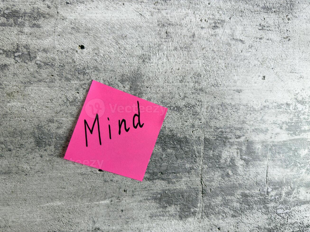 Bright pink sticky note featuring the word Mind placed on a textured grey background, symbolizing concepts of mindfulness, awareness, and mental clarity for personal growth and inspiration photo