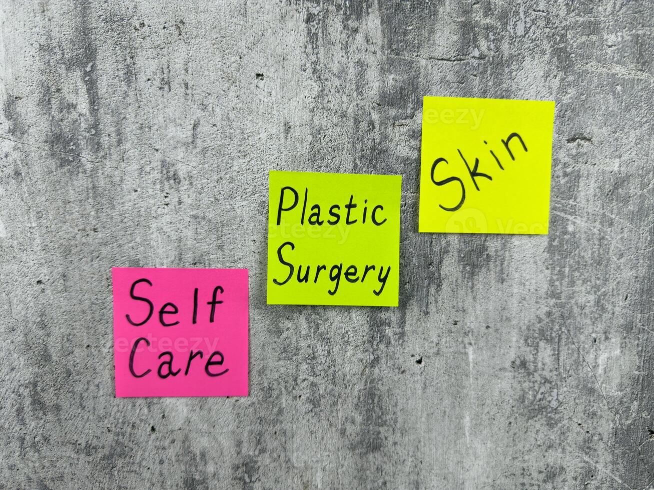 Bright sticky notes with words about taking care of your health. Important reminder on shabby background with words about plastic surgery and skin care photo