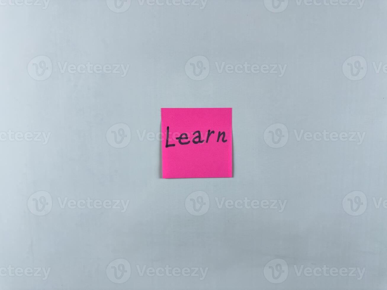 Sticky note on white background with word Learn. Concept of continuous learning and personal development. Development and acquisition of new information through learning photo