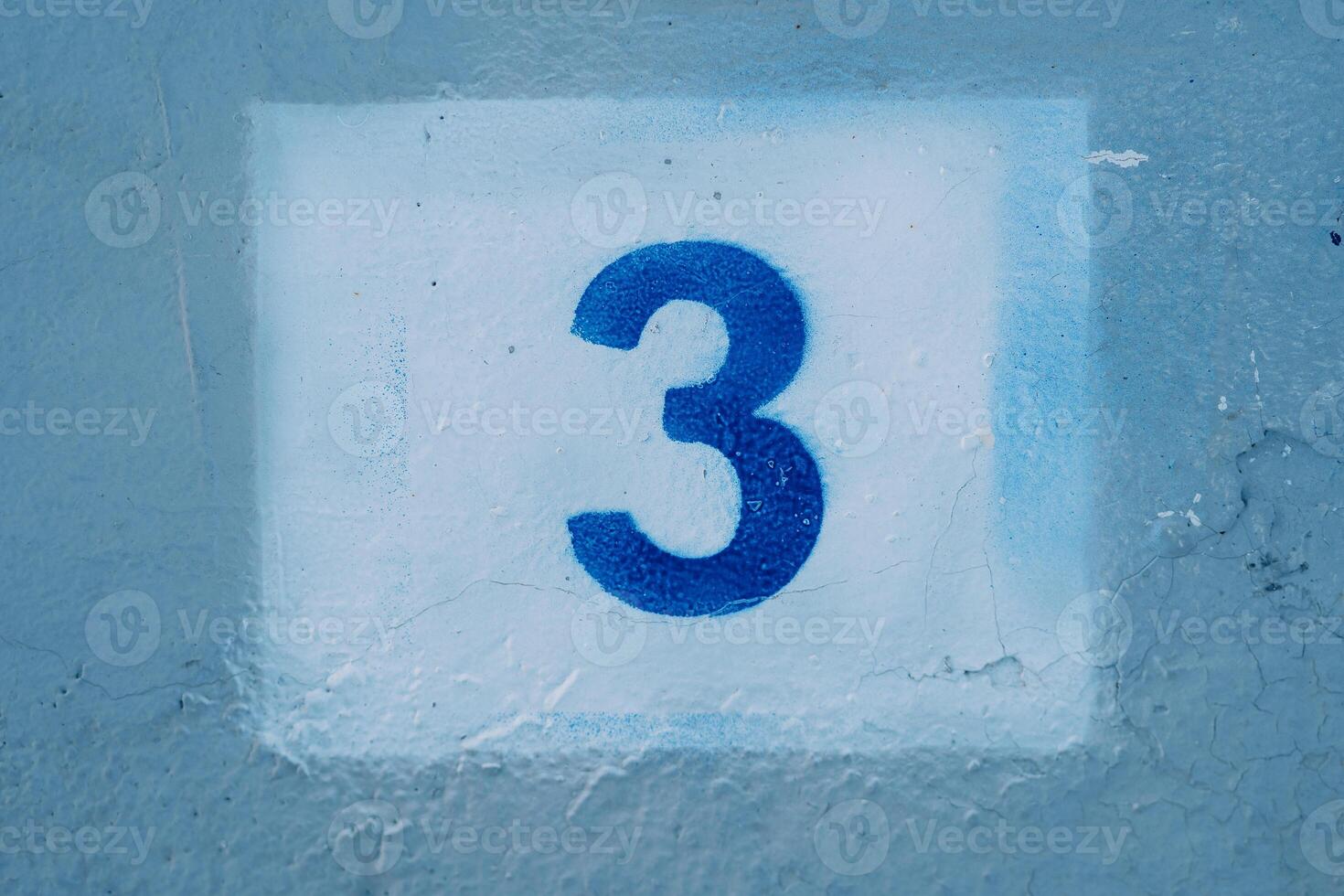 Number three drawn on a blue wall in a white rectangle photo