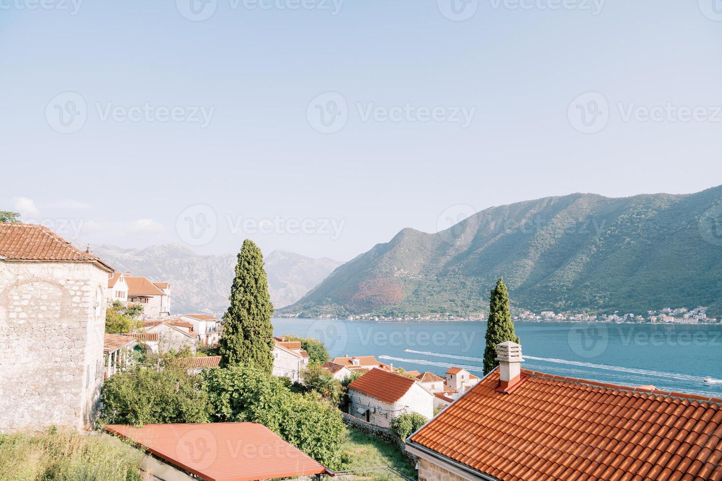 View of the Bay of Kotor over the red roofs of old houses surrounded by trees. Montenegro photo