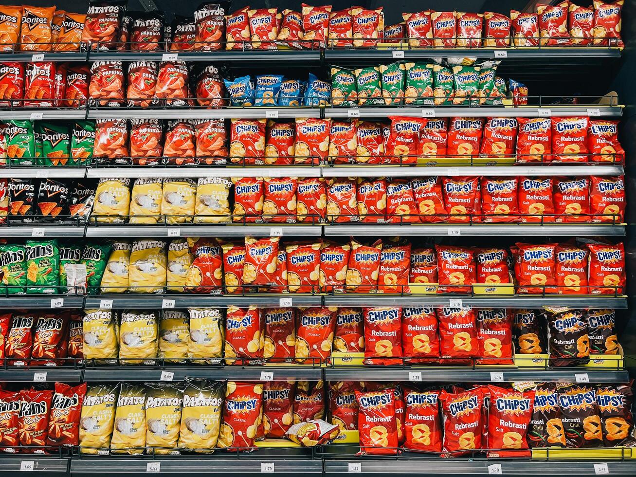 Budva, Montenegro - 18 august 2023. Assortment of bags of chips on the shelves in the supermarket photo