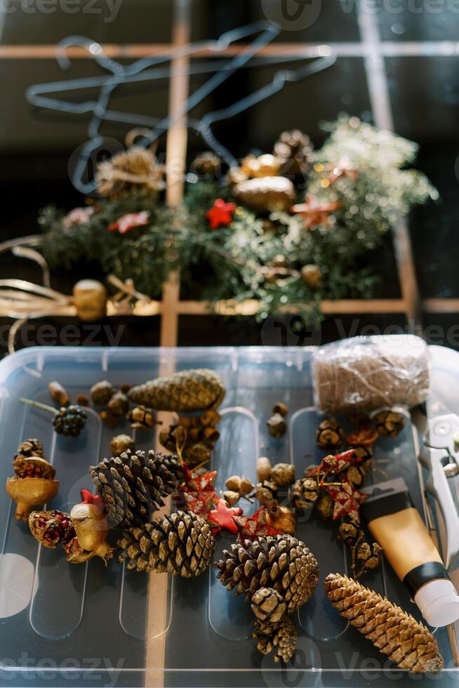 Fir cones, balls, threads and scissors for making a New Year wreath lie on the table photo