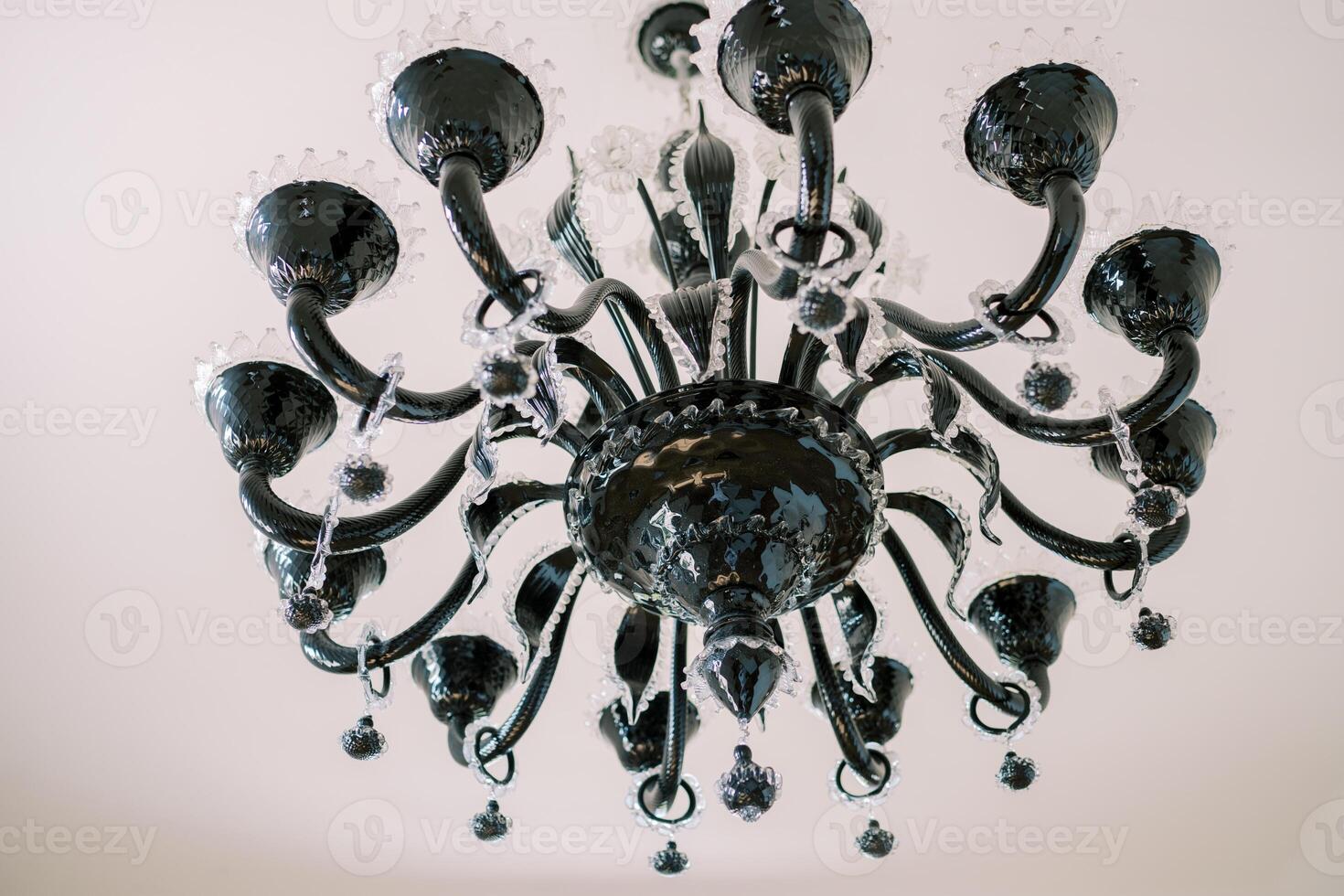 Black chandelier with white glass decor and pendants hangs on the ceiling photo