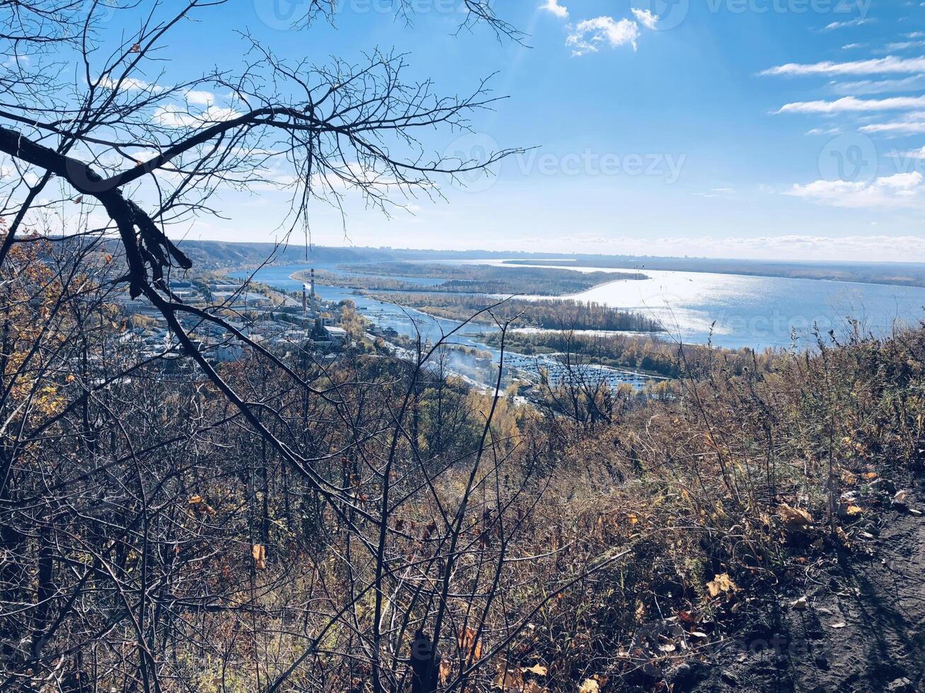Breathtaking autumn view from a hillside overlooking a serene river and vibrant landscape in the heart of nature photo