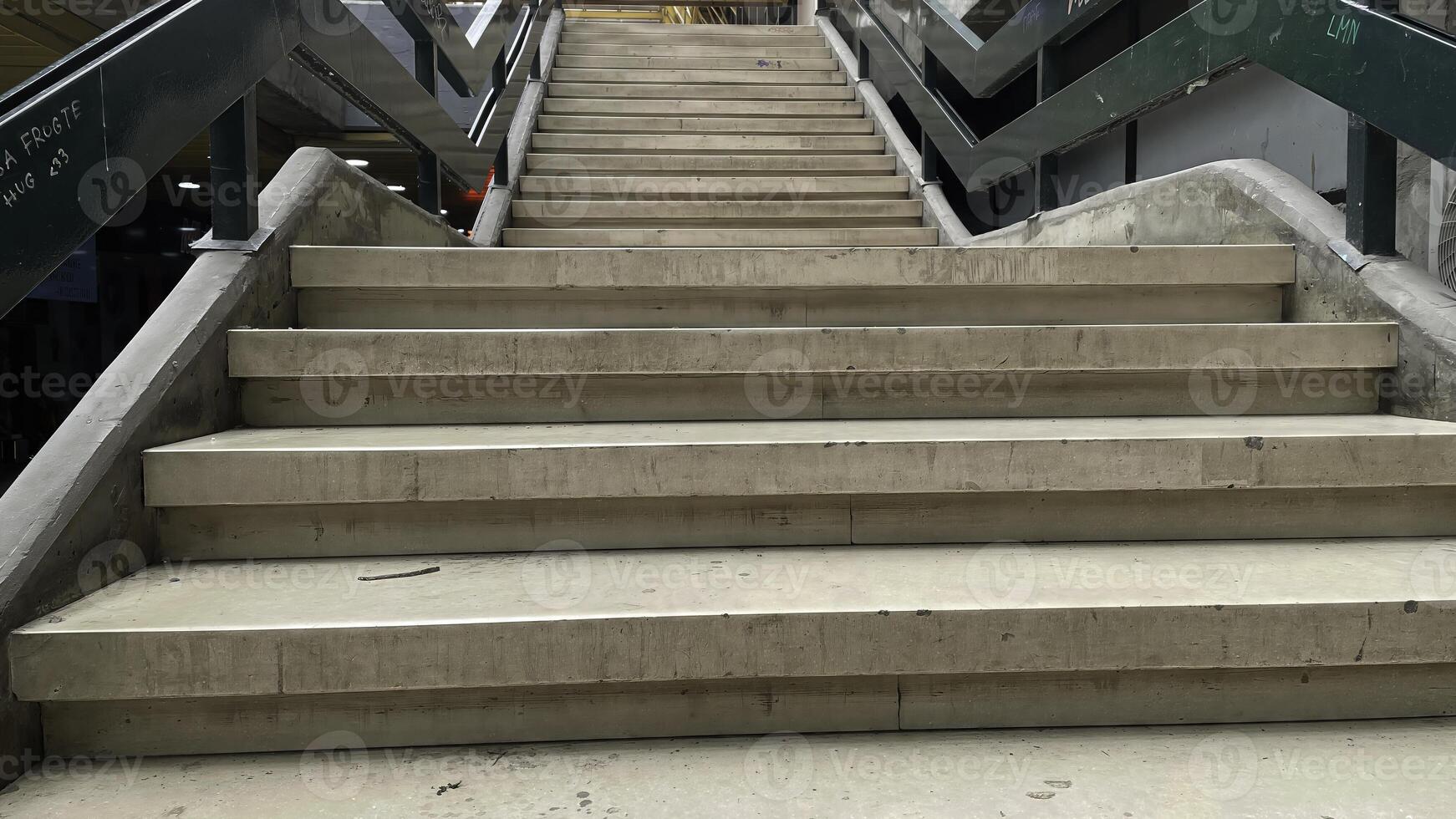 Modern architectural staircase leading upward in a spacious indoor environment filled with natural light and activity photo