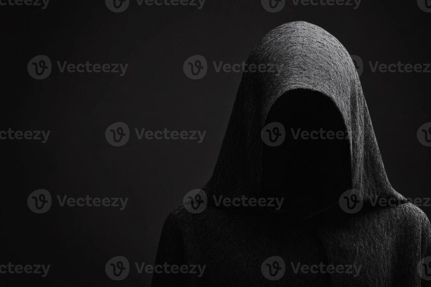Mysterious figure cloaked in darkness stands silently in an enigmatic atmosphere, evoking curiosity and intrigue photo