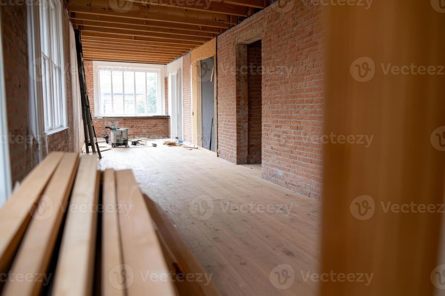 Renovation of a spacious interior hallway with wooden flooring in a brick building in progress photo