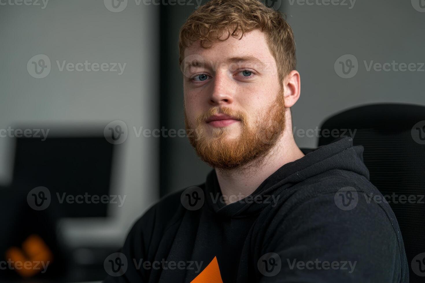 Young man with a beard focused on his work in a modern office environment during daytime photo