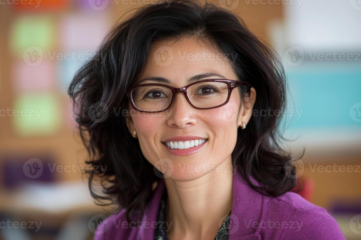 Smiling educator in a classroom setting with colorful bulletin boards in the background during a bright day photo
