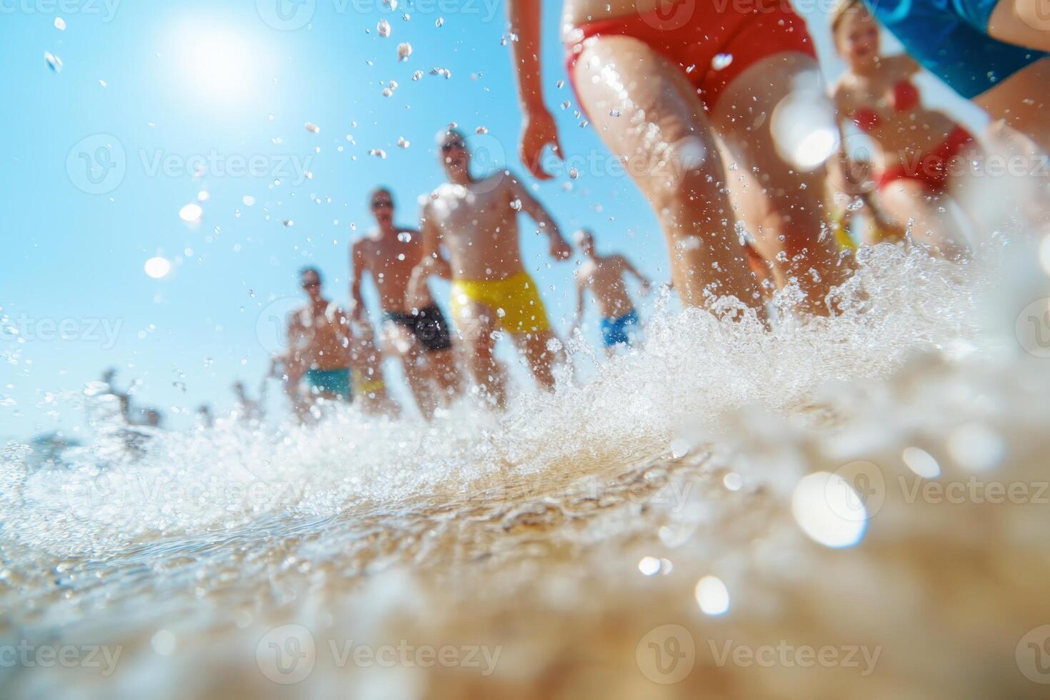 People enjoying a sunny day at the beach while splashing through shallow water during summer photo