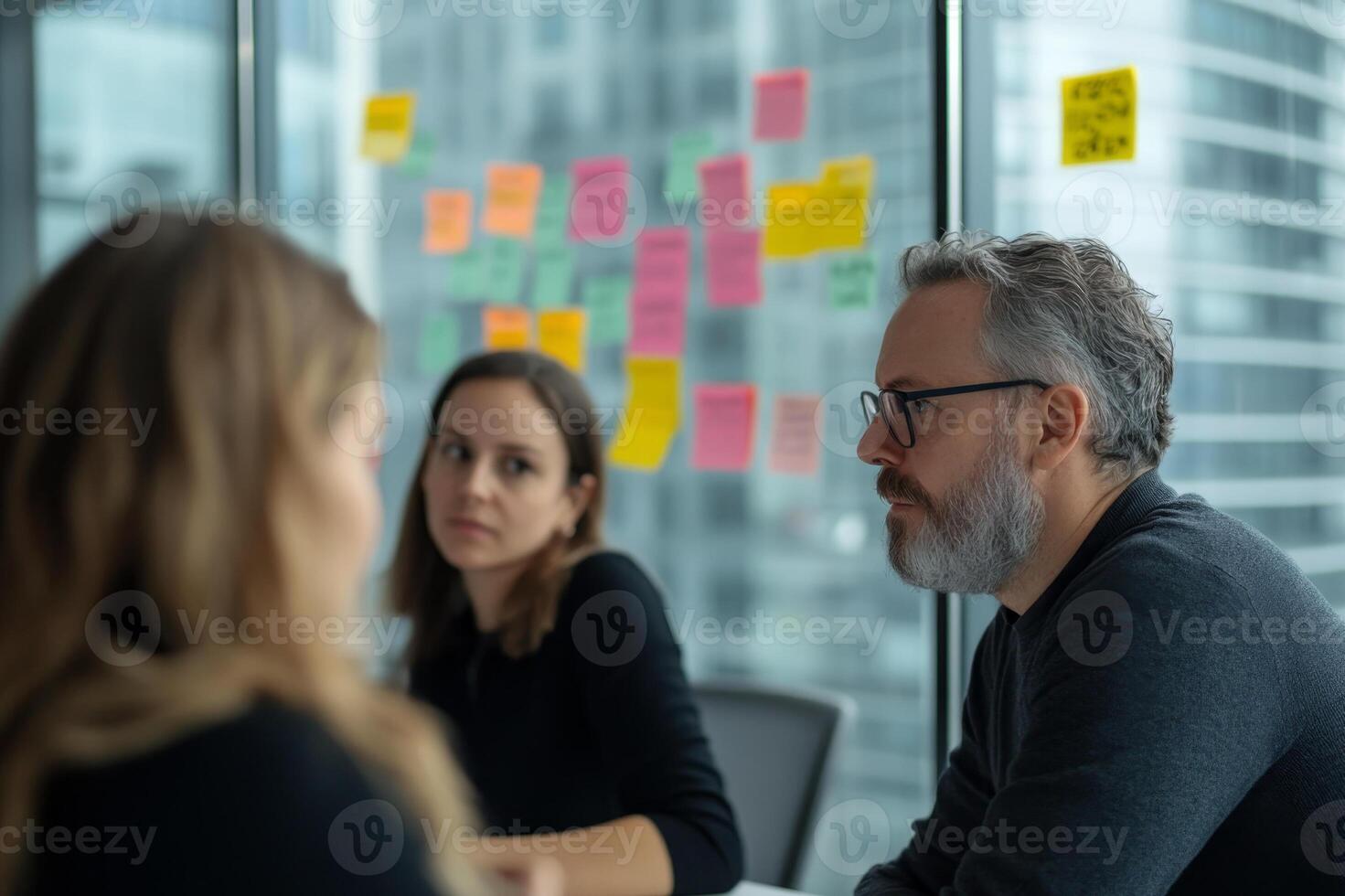 Meeting with team members discussing project ideas in a modern office environment during daylight hours photo