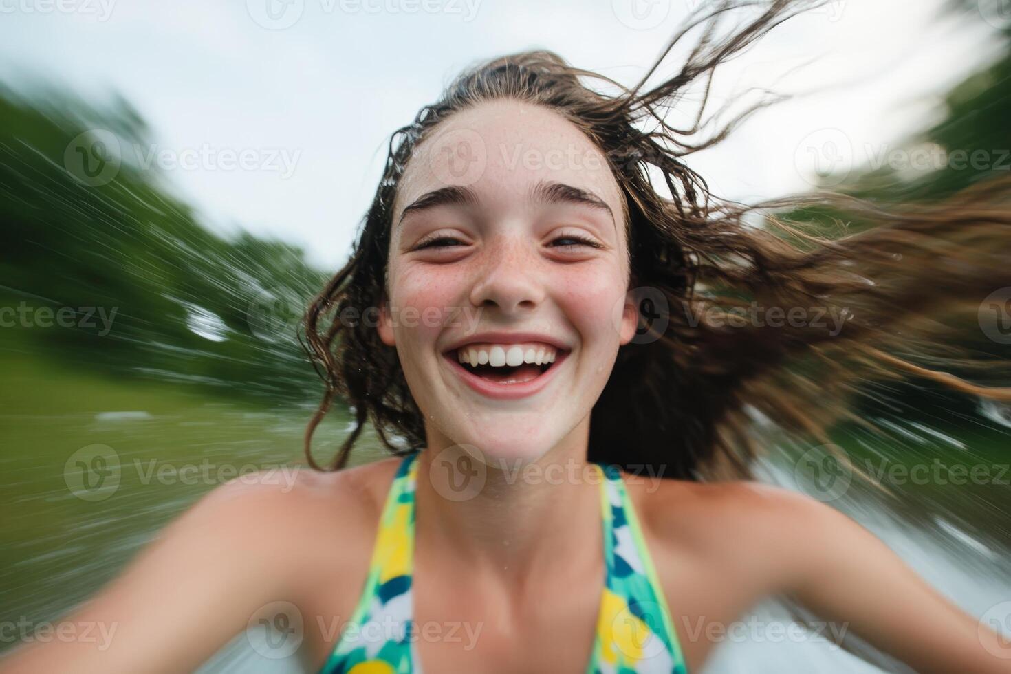 Joyful girl on a summer day enjoying a thrilling ride while splashing through water at a lakeside location photo