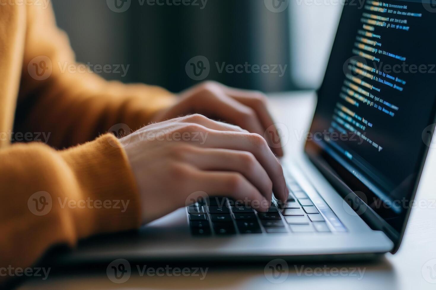 Person coding on a laptop with focused hands in a cozy indoor environment during daytime photo