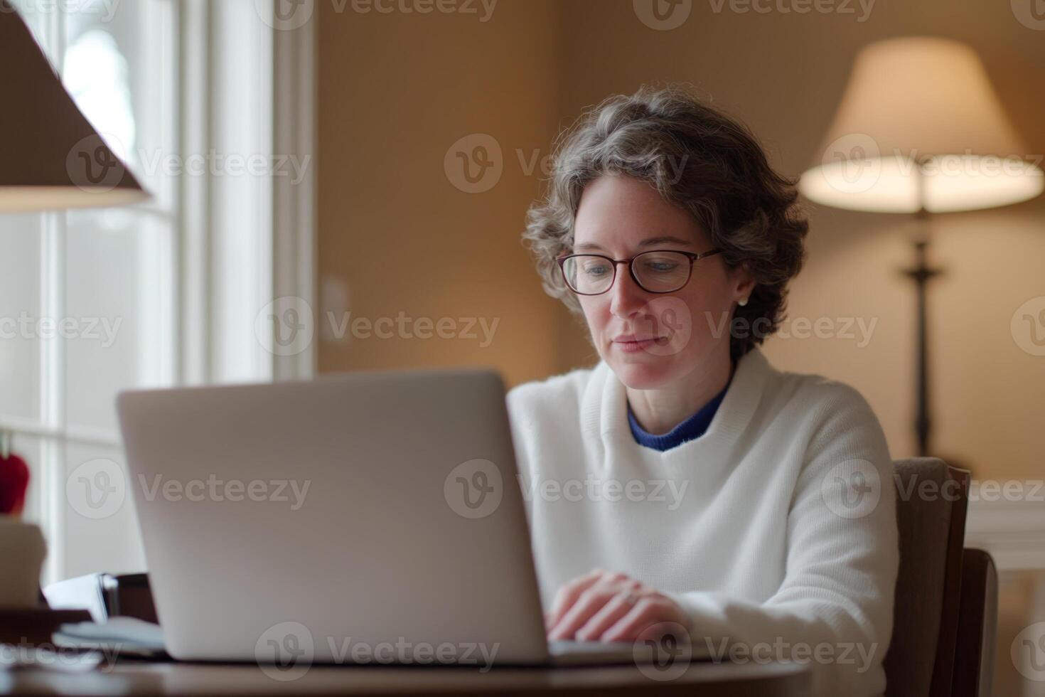 Individual working on a laptop in a well-lit indoor space during the day photo